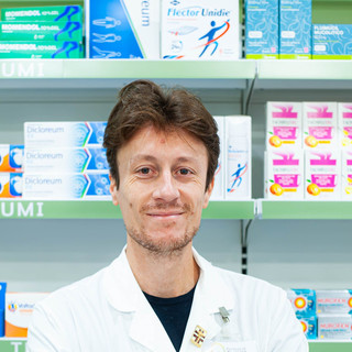 Monti dietro il bancone della sua farmacia
