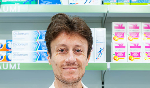 Monti dietro il bancone della sua farmacia