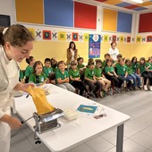 Alcuni momenti dell’istruttivo incontro alla scuola “Rodari” con i bambini intenti a seguire la singolare “lezione” di cucina