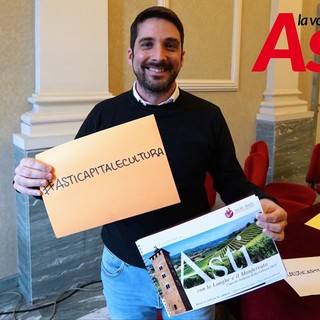 Nell'immagine (ph. Efrem Zanchettin), l'assessore Candelaresi ritratto mentre mostra uno degli hashtag associati alla candidatura astigiana