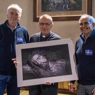 Rappresentanti della sezione fotografia della Polisportiva CRAT ritratti con il vescovo Prastaro cui hanno donato una delle loro foto