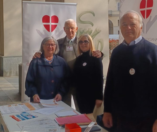 Alcuni volontari della Fondazione ritratti ad un banchetto informativo allestito in piazza Alfieri