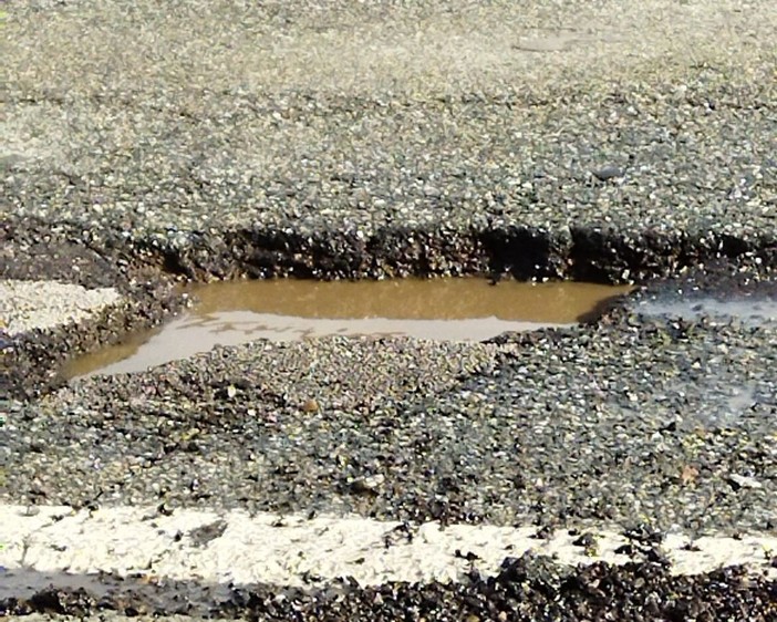 Una foto postata sui social che documenta le buche che si sono aperte sul fondo stradale