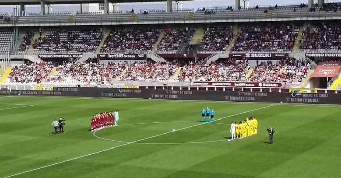 I giocatori raccolti a centrocampo per il minuto di silenzio